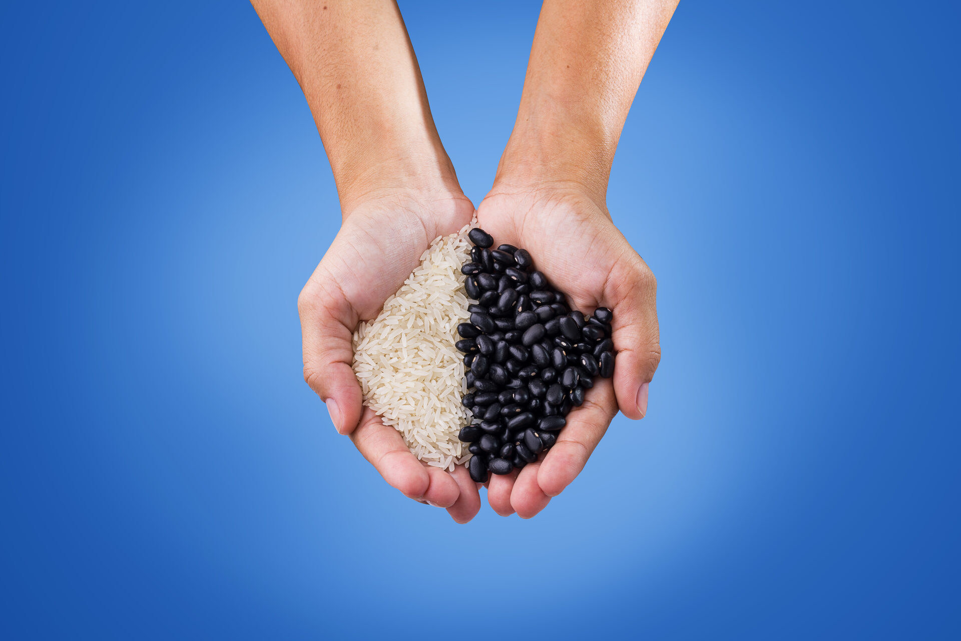 Still gastronômico de arroz e feijão nas mãos